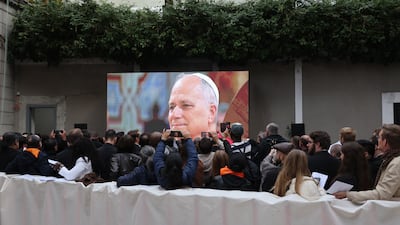 A crowd watches a broadcast of the Pope's visit to the 19th century cathedral. Getty Images