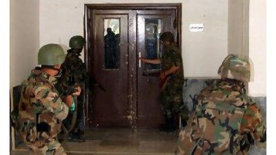 Syrian army soldiers search inside the hospital in the town of Jisr al Shughour, north of Damascus, Syria. Syrians poured across the border Monday to refugee camps in Turkey, fleeing a military crackdown that sent elite forces backed by helicopters and tanks into the town. Bassem Tellawi / AP Photo