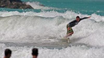 A surfer rides the waves at the Jumeirah open beach next to the Burj Al Arab hotel in Dubai in March.