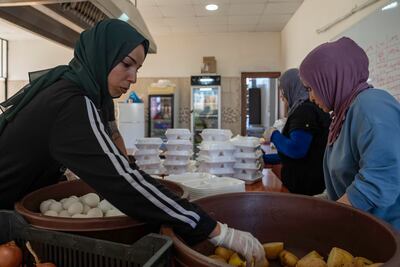 Displaced people prepare rudimentary meals for up to 800 people every day in the municipality headquarters in Tyre. Matt Kynaston / The National