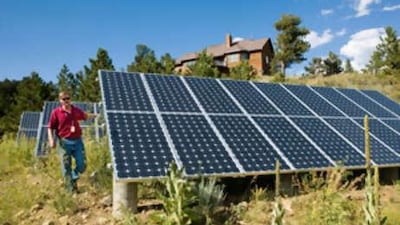 Joe Gierlach, a local resident, walks past his solar panels at his mountain home in Nederland, Colarado.