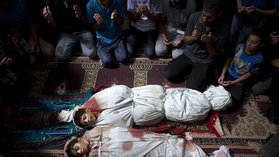 Family members pray in the mosque in Sajeria, Gaza by the bodies of Amir, Mustafa Arief and Mohammed during their funeral in Sajeria, Gaza. The brothers were killed together near their home allegedly by an Israeli drone.