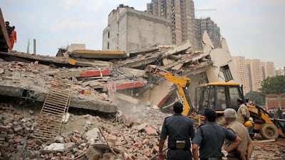 A backhoe is operated at the site of a collapsed building in Shahberi village. AP Photo
