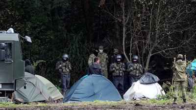 Polish security forces surround migrants stuck on the border with Belarus in Usnarz Gorny, Poland. AP Photo