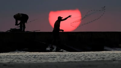 A fisherman casts his net along a jetty at sunrise in Port Aransas, Texas. The coastal bend area is still recovering from the effects of Hurricane Harvey. Eric Gay / AP Photo