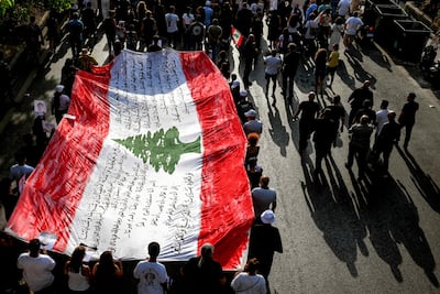 Family members and relatives of the victims of the 2020 Beirut port explosion march with a giant Lebanese flag on the sixth anniversary of the incident near the port area in Beirut. AFP