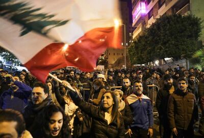 Lebanese protesters wave the national flag as they gather outside the house of Lebanon's new prime minister in Beirut. AFP
