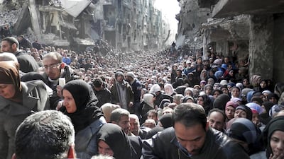 Residents of the Yarmouk Palestinian camp in Damascus queueing for food handouts on January 31, 2014. UNRWA via AP