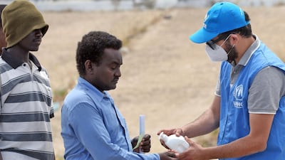 A man sanitises his hands to protect against the coronavirus before collecting aid at a United Nations camp for displaced Libyans and asylum seekers. AFP