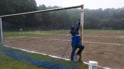 A man fixes the net on a football field at the Teoca volcano crater in the town of Santa Cecilia Tepetlapa, on the outskirts of Mexico City. AFP