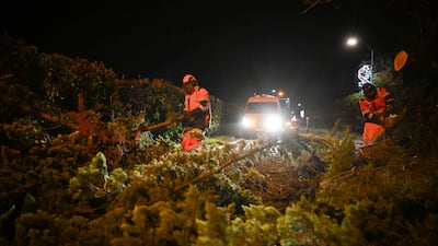 Workers clear a road in Banville, north-west France, after Goretti passed. AFP