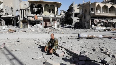 A fighter of Syrian Democratic Forces rests on rubble after Raqqa was liberated. Erik De Castro / Reuters