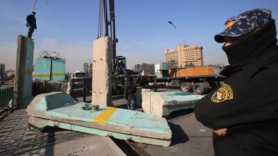 Members of the Iraqi security forces look on as municipal workers clean the al-Sinek bridge, connecting the Iraqi capital Baghdad's Sinek district to the Salhiyeh district neighbouring the high-security Green Zone, which hosts government offices and foreign embassies, in Baghdad. AFP