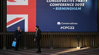Delegates take a break outside the venue on the opening day. AFP
