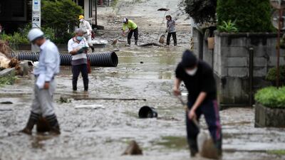 Residents clean a street covered with mud following floods in Oe city, in north-eastern Japan, on August 4, 2022. Large areas of north-eastern and central Japan were hit by torrential rainfall, and more than 100,000 residents were asked to evacuate. EPA