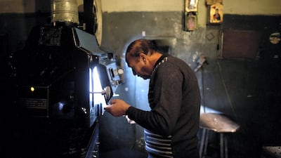 Cinema operator Rassoul changes a film roll as he shows a Bollywood movie at Cinema Park in May 2012. AFP