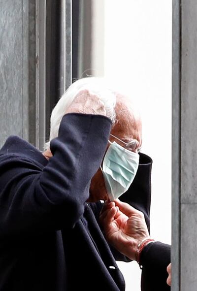 Designer Giorgio Armani puts on a face mask as he arrives at the venue during Milan Fashion Week on February 23. Reuters