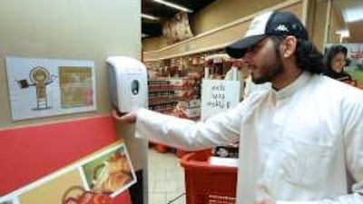 Mustafa Mirza, a shopper, uses hand sanitiser in the Aswaaq supermarket in Dubai's Al Mizhar area yesterday.