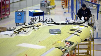 A technician works on the wing of an Airbus A320 during construction at the Airbus factory in Broughton, United Kingdom. Airbus, which had 137,000 workers worldwide in July, has committed to curbing production of the A380 superjumbo amid a decline in sales. Christopher Furlong / Getty Images