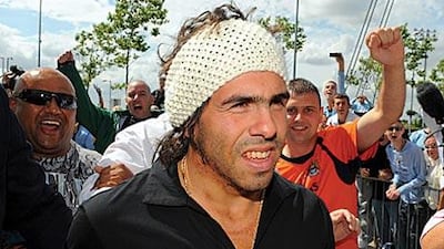 Fans and media jostle for position as Carlos Tevez, centre, arrives at the City of Manchester stadium yesterday. Manchester City signed the Argentine striker, who spent the past two seasons with Manchester United.
