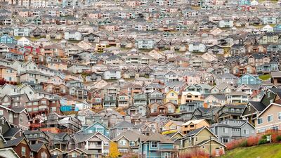 ‘Garden of Earthly Delights’ by Eric Tomberlin is made up of 150 photos of houses in Seattle, which seem to encroach on the playground in front. Courtesy Gulf Photo Plus