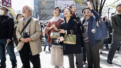 People react as they watch a news broadcast of Japan's Chief Cabinet Secretary Yoshihide Suga unveiling the name of Japan's next imperial era. Bloomberg
