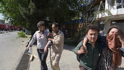 Afghan men provide assistance to the wounded at the site of the car bomb attack in Kabul. Shah Marai / AFP