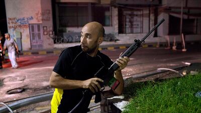 epa02877454 A rebel in a makeshift checkpoint during the night after the rebels entered in Tripoli, Libya, on 22 August 2011. US President Barack Obama called on 22 August 2011 for 'an inclusive transition that leads to a democratic Libya,' after the fall???