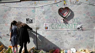 People write messages on a wall for the victims and in support of those affected, shortly after the fire in 2017. AP