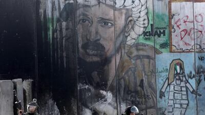 The image of former Palestinian president Yasser Arafat looks over Israeli security forces near Ramallah. Israel is trying to paint Mahmoud Abbas as another Arafat. Photo: Abbas Momani / AFP