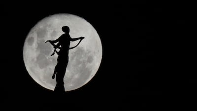 The wolf moon rises behind the Victorious Peace statue, in Asuncion, Paraguay. AP