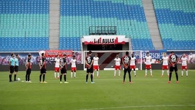Players observe a minute's silence for the victims of the coronavirus prior to the match. AFP