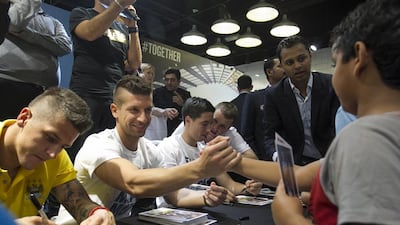 Manchester City player Stevan Jovetic, centre, shakes a young fan's hand while Matija Nastasic, left, and Samir Nasri, right, sign autographs during their appearance at Marina Mall in Abu Dhabi on Tuesday. Mona Al-Marzooqi / The National / May 13, 2014