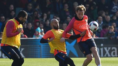 Javier Mascherano, centre, vies with Ivan Rakitic, right, and Arda Turan, left. Lluis Gene / AFP