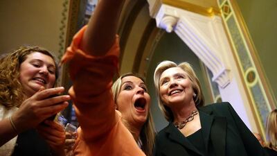 Democratic presidential hopeful and former Secretary of State Hillary Clinton (R) stops to take a selfie on the road on Iowa (Justin Sullivan/Getty Images/AFP)