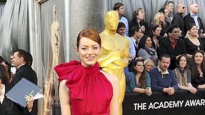 2012: Emma Stone makes her Oscars debut in a high neck red gown by Giambattista Valli. AFP
