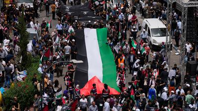 Palestinians carry a large national flag during a Nakba Day rally to mark the displacement of thousands of Palestinians after the founding of the Israeli state in the aftermath of the Second World War. AP