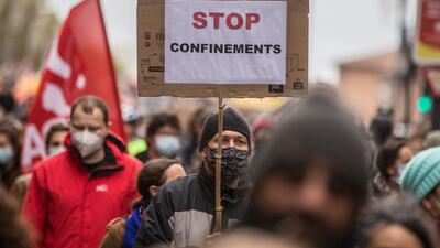 A protester, wearing a face mask, holds a sign reading 'stop lockdowns' in Toulouse. AFP
