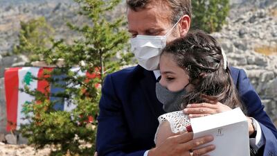 French President Emmanuel Macron hugs a blast victim while attending a ceremony to mark Lebanon's centenary in Jaj Cedars Reserve Forest on September 1, 2020. AFP