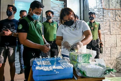 Agents place tags on the bags of seized drugs. AP