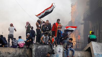 An Iraqi demonstrator carries the Iraqi flag during ongoing anti-government protests, in Baghdad. REUTERS
