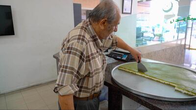 Sweet maker Mohammed Al Daouk cuts up a batch of Daoukiye, the Beirut Ramadan treat named after him. Mahmoud Rida / The National
