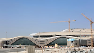 A passenger boarding bridge, left, sits beside an aircraft parking area under development Abu Dhabi airport's MidField terminal during construction in Abu Dhabi, United Arab Emirates, on Monday, Nov. 6, 2017. The project will cost 19.1 billion dirhams, will have a capacity to handle 84 million passengers, or 11,000 passengers per hour and have 65 gates. Photographer: Natalie Naccache/Bloomberg
