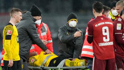 Dortmund's Julian Brandt, centre, leaves the field on a stretcher after a collision with Bayern's Dayot Upamecano. AP Photo