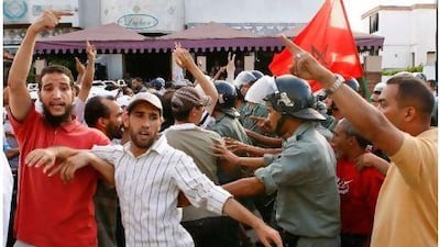 Police officers protect democracy activists from pro-government demonstrators trying to attack them in Rabat on Sunday. Abdeljalil Bounhar / AP Photo