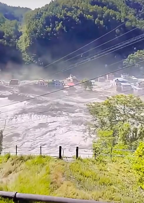 The swollen river water sweeps away homes and buildings as people run to safety in Nuwakot, one of Nepal’s worst-hit flood districts, on August 26. Harisharan Gajurel / Facebook