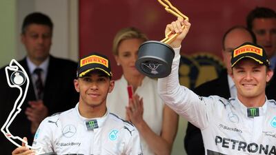 Mercedes' German driver Nico Rosberg, right, holds his trophy next to Mercedes' British driver Lewis Hamilton on the podium of the Monaco street circuit after winning the Monaco Formula One Grand Prix in Monte Carlo on May 25, 2014. AFP PHOTO / ALEXANDER KLEIN