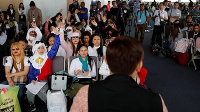 A labour official speaks to Filipino workers who had been repatriated from Kuwait, in Manila in 2018. Reuters