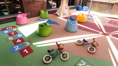 The outdoor play area is filled with bicycles, teepees and bean bags
