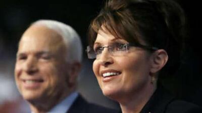 Senator John McCain looks on as his vice-presidential running mate, the Governor of Alaska Sarah Palin, speaks at a campaign event in Dayton, Ohio on Aug 29.